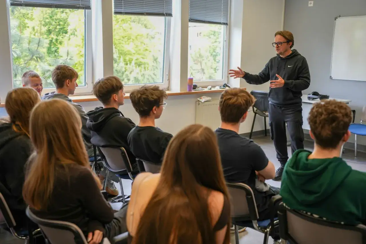 Nauczyciel prowadzi kurs pedagogiczny dla grupy młodzieży.