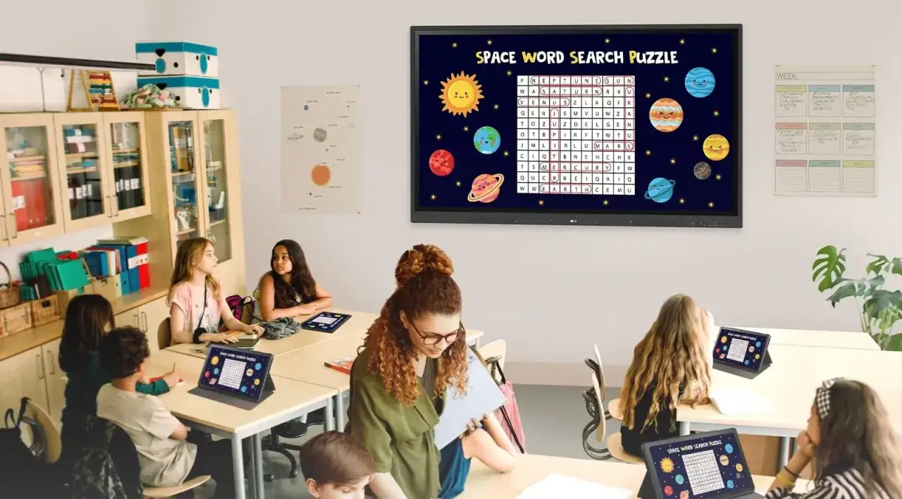 Uczniowie rozwiązują kosmiczną łamigłówkę na tabletach, a na tablicy interaktywnej wyświetla się podobne zadanie. To przykład innowacji pedagogicznej.